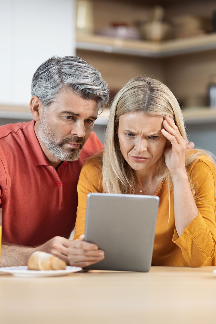stressed middle aged couple surfing on a tablet