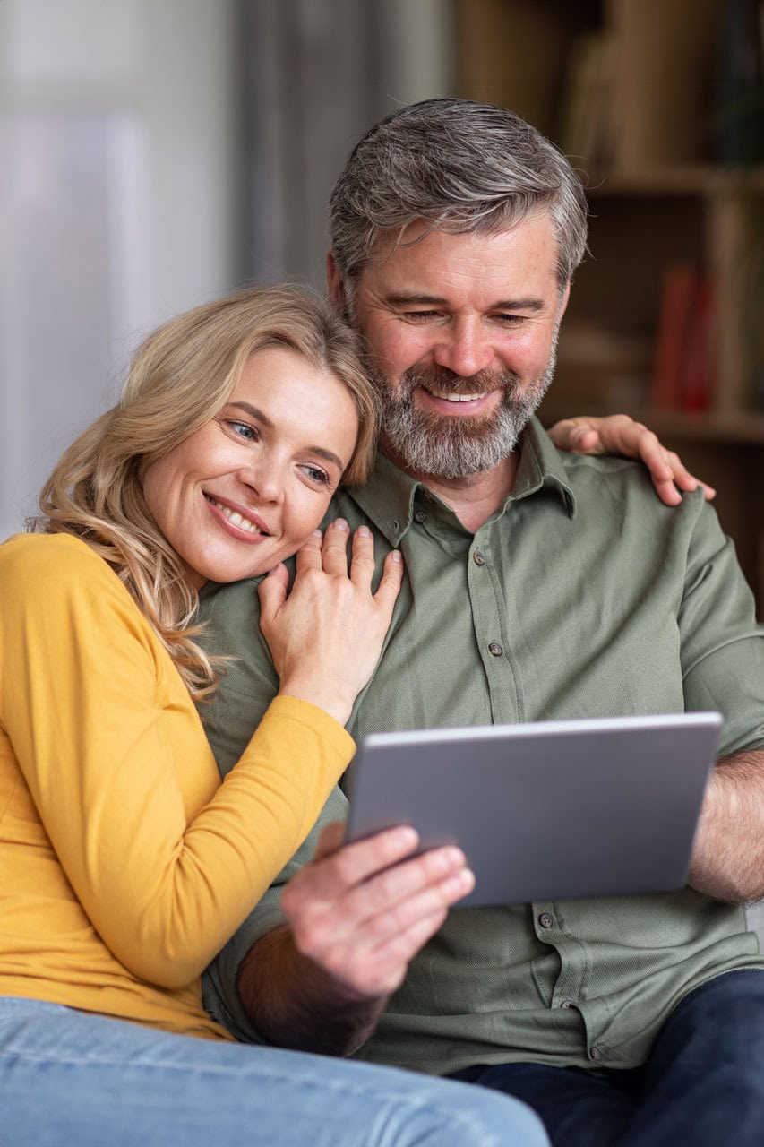 Happy middle aged couple browsing on a tablet together