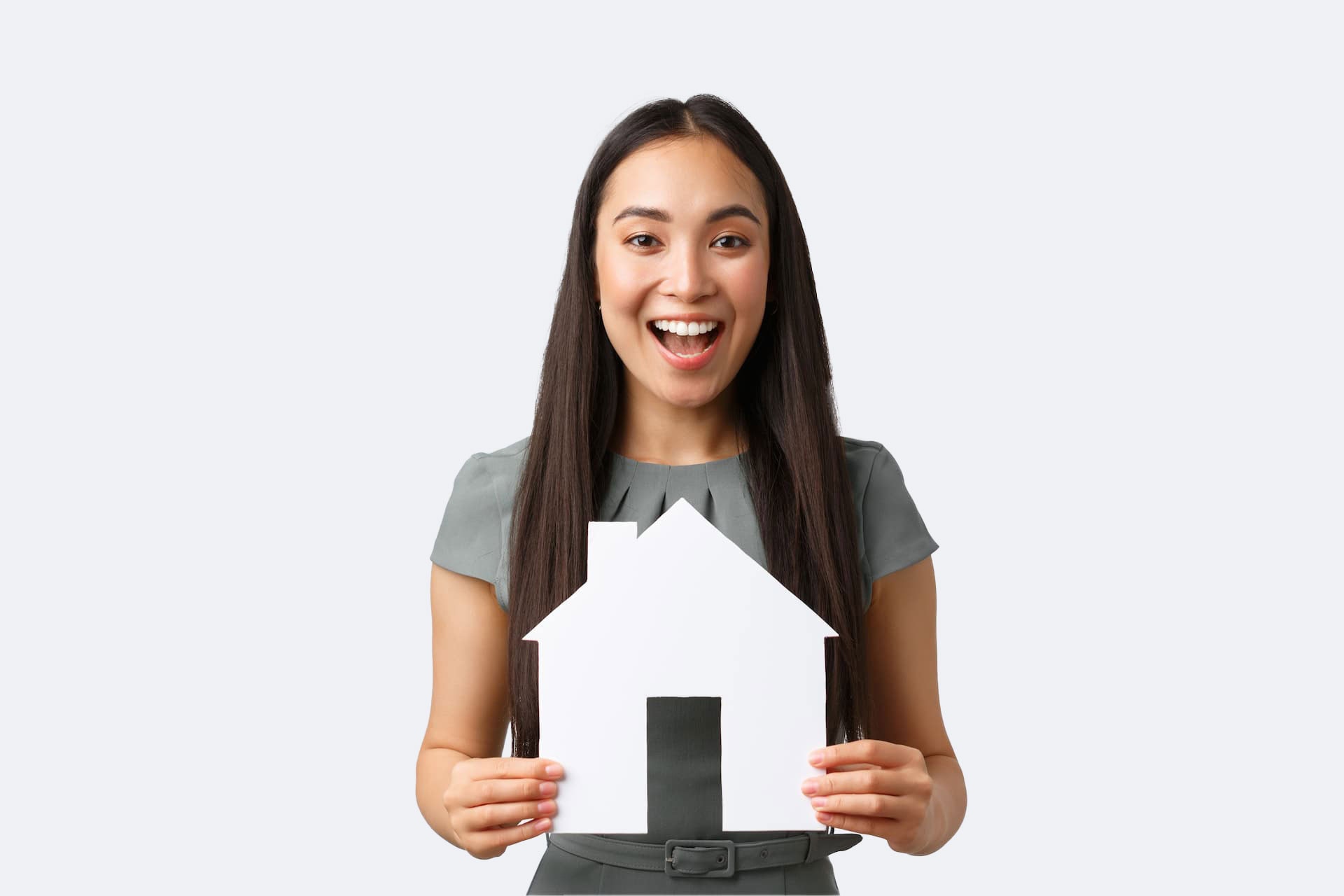 young woman with a cut out of a house on a pale grey background